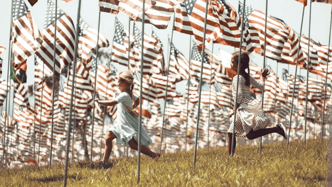 Дети бегут по полю с американскими флагами